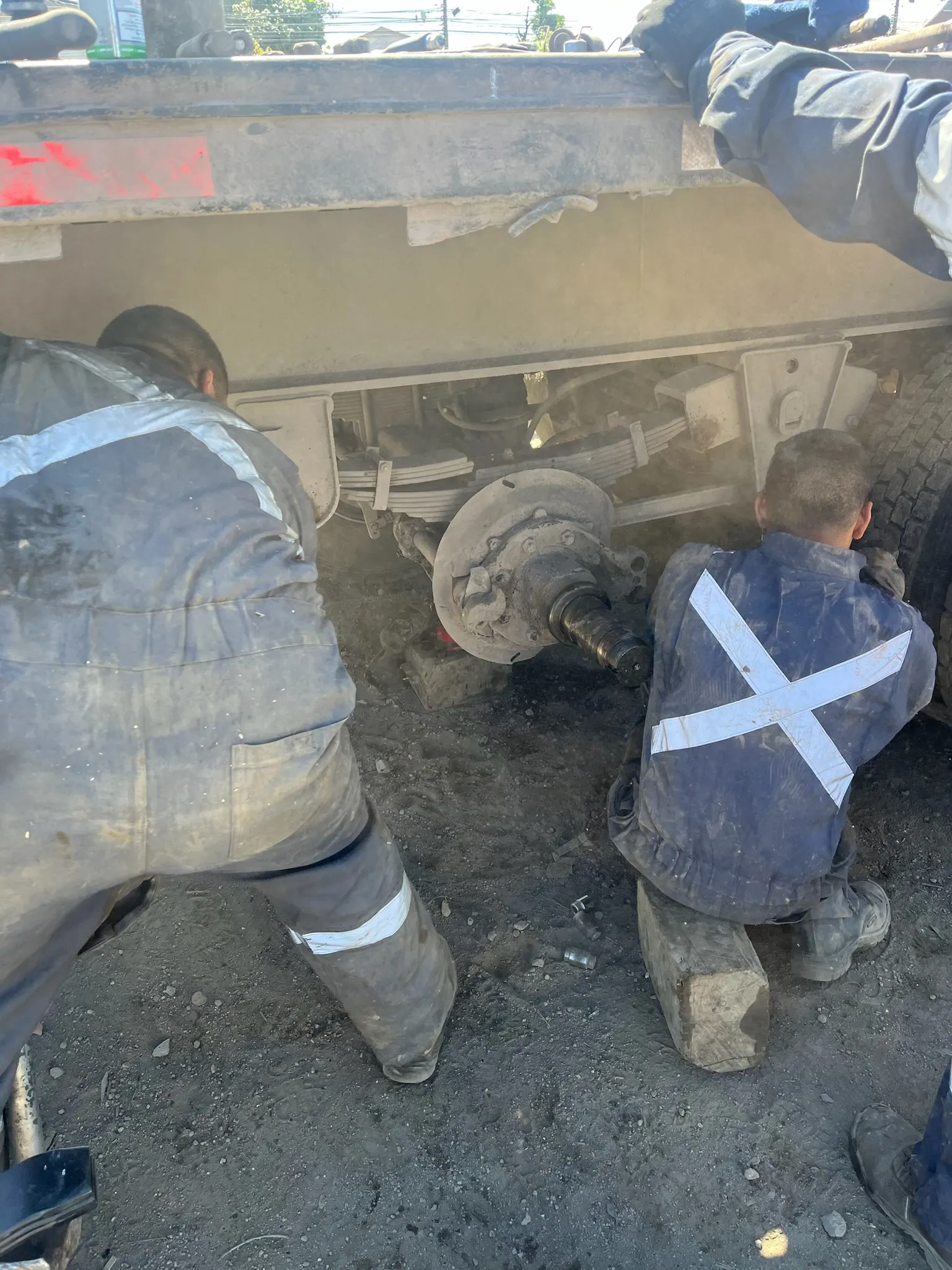 Técnicos revisando frenos de camión